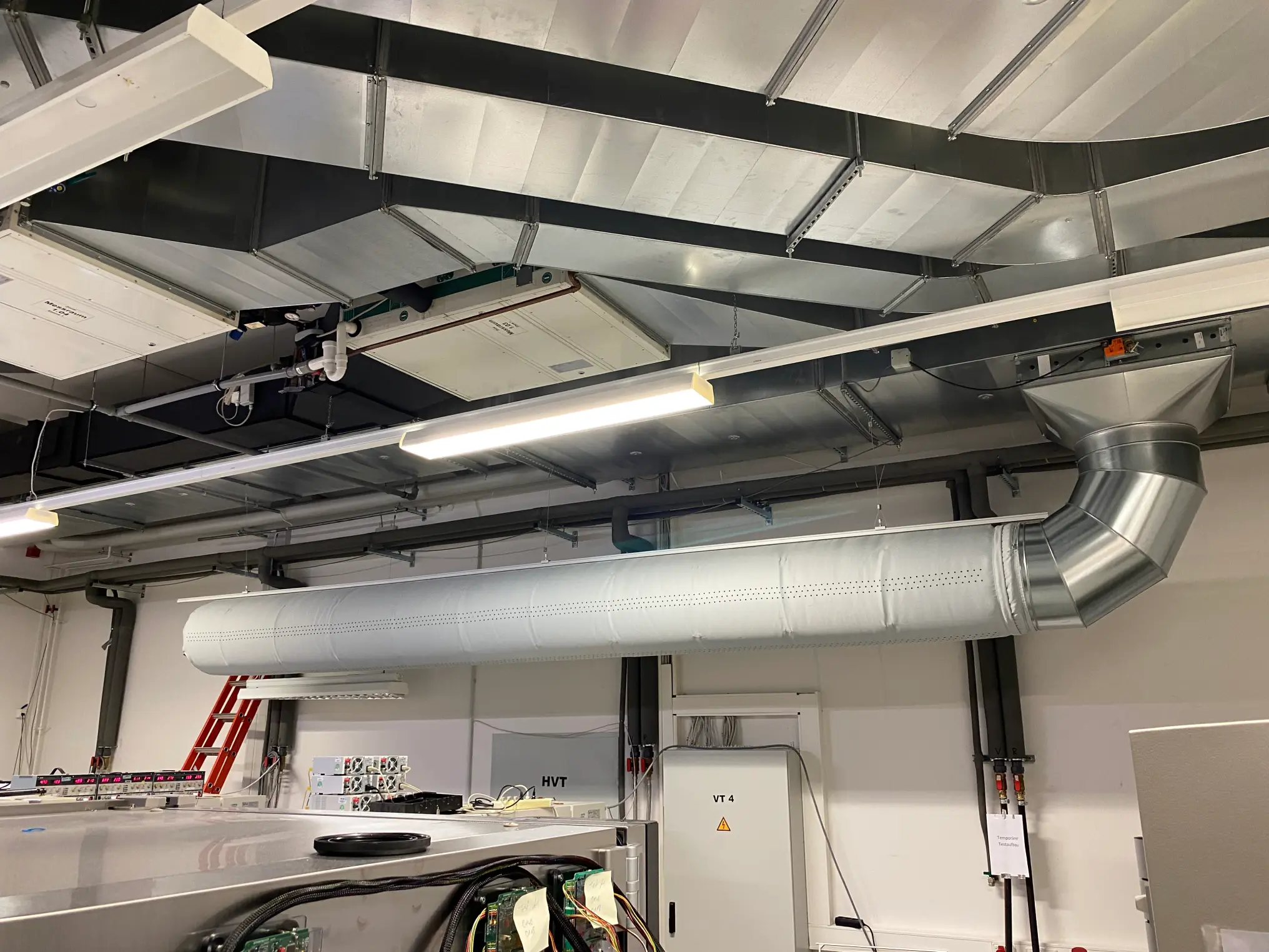 AIRnorm GmbH – gleichmäßige und zugluftfreie Zuluftverteilung gekühlter Frischluft über perforierte Rundkanäle und Luftleitungssystem in einer Industriehalle
